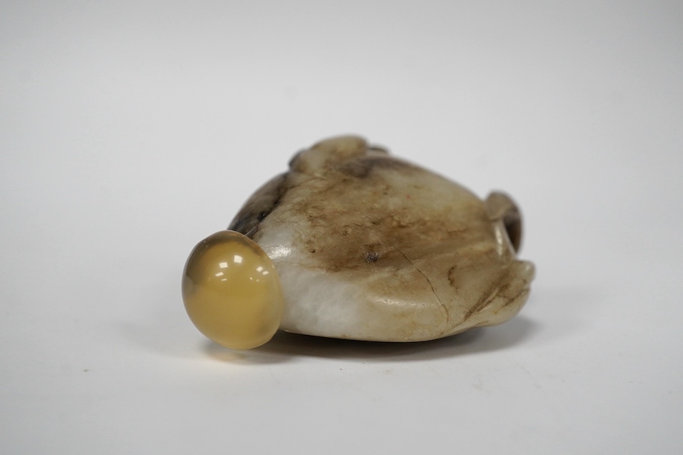 A Chinese white and black jade pendant now hollowed as a snuff bottle, and a Chinese celadon jade figure of a buffalo. Condition - fair to good